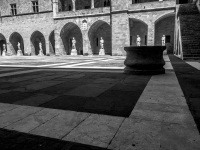 the inner courtyard of the grandmaster palace in rhodes with many statues, black-and-white