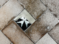 an old floor with brown tiles and with one malteser-tile in filerimos on rhodes