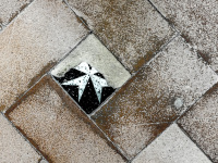 an old floor with brown tiles and with one malteser-tile in filerimos on rhodes