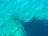 the shadow of the ship's bow of the ship magelanos in turquiose sea near stegna on rhodes