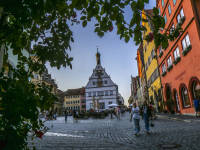 a street szene with colorful houses and people at sunsetlight at the marketplace in rothenburg ob der tauber in germany