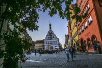 a street szene with colorful houses and people at sunsetlight at the marketplace in rothenburg ob der tauber in germany