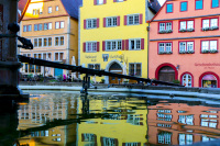 colorful houses at the marketplace in rothenburg ob der tauber in germany are relected in the water of a fountain