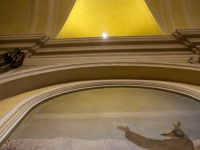 an arch, a light and a fresco painting in the church san francesco in san marino in italy
