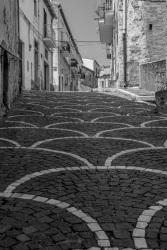 a nice architectural street with white houses in bovino in puglia, black-and-white