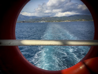 view through a porthole to the wake of a ferry between rio and antirrio in greece