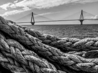 big ropes in the front of the gulf of corinth and in the background you see the rio antirrio bridge near patras, black-and-white