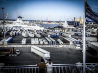 a truck ist driving on a ferryboat at harbor in bari in italy, many trucks are still waiting