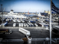 a truck ist driving on a ferryboat at harbor in bari in italy, many trucks are still waiting