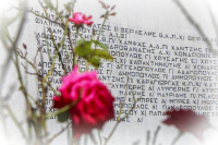 roses are in the front of a memorial stone which is signed with the names of the victims of the massacre in kalavrita in WW2