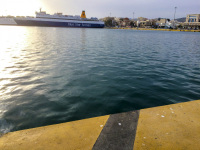 view from the shore and the sea in piraeus to a ferry boat of blue star ferries in an evening light