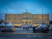 the illuminated greek parliament at the synthagma in athens with traffic in front at an evening light
