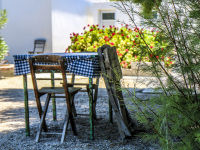 in a tavern in glyfada on rhodes stands a idyllic wooden seating group with a table and two chairs