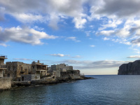 in the bay of gerolimenas are standing typical houses of the region mani at the sea in a evening light