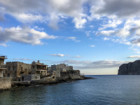 in the bay of gerolimenas are standing typical houses of the region mani at the sea in a evening light