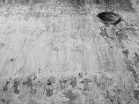 a wheathered wall with a window like a porthole in eleousa on rhodes, black-and-white