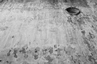 a wheathered wall with a window like a porthole in eleousa on rhodes, black-and-white
