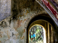 two tourists are standing behind a ruin in eleousa on rhodes, you see them through a stone arch
