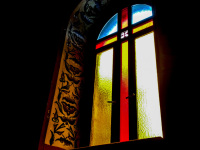 the colorful window with a cross of the church of the dormition of the virgin in kalavrita