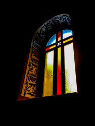 the colorful window with a cross of the church of the dormition of the virgin in kalavrita