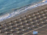 parasols and sunbeds are standing lined up in order at the beach akti kanari in ialysos on rhodes