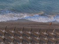 lined up standing umbrellas and beach chairs at the beach akti kanari on rhodes on sunset