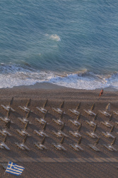 lined up standing umbrellas and beach chairs at the beach akti kanari on rhodes on sunset
