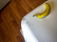 a banana is laying on the white bed next to the wooden floor in the hotel the regent boutique hotel & spa in san marino in italy