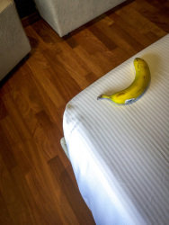 a banana is laying on the white bed next to the wooden floor in the hotel the regent boutique hotel & spa in san marino in italy