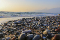 many stones at the limni beach near apolakkia on rhodes with the sea behind and a sunset