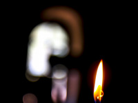 a small red candle is burning i the dark fountoukli church in eleousa on rhodes