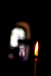 a small red candle is burning i the dark fountoukli church in eleousa on rhodes