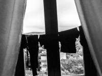 at the window in a hotel room in the residenza ducale in bovino is hanging a clothes line with black clothes, black-and-white