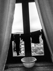 at the window in a hotel room in the residenza ducale in bovino is hanging a clothes line with black clothes, black-and-white