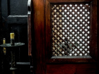 a darkbrown wooden confessional in the diocesan musum of bovino in puglia in italy