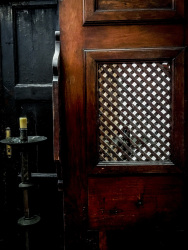 a darkbrown wooden confessional in the diocesan musum of bovino in puglia in italy