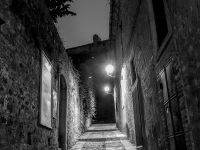 a loneley leading upwarts alley wiht cobblestonesby night in bovino in puglia, black-and-white