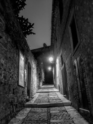 a loneley leading upwarts alley wiht cobblestonesby night in bovino in puglia, black-and-white