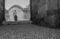 a path of cobblestones lead to the church kimisis theotokou in asklipio on rhodes, black-and-white