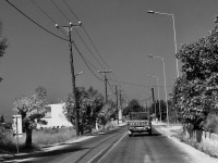 an old toyota pickup is driving on a street near kalavarda on rhodes along old electricity pylons, black-and-white