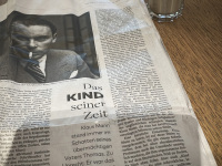 the newspaper \"Die Welt\" with an article about Klaus Mann an a glass of latte macchiato on a table at the swiss lounge at the airport in zurich