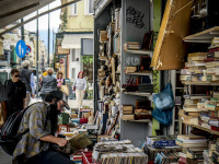 a man rummages in vinyl records outside of a shop in monastiraki in athens