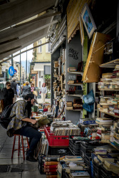 a man rummages in vinyl records outside of a shop in monastiraki in athens
