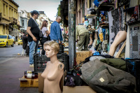 the naked bust of a display dummy and a lot of other flea market objects are standing at the street in front of shop in monastiraki in athens