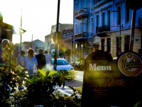 behind a menu sign of the restaurant dipilo in monastiraki in athens pedestrian are going in the backlight
