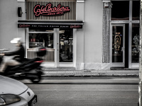 in front of the café barbera in monastiraki in athens a motorcyle pass the street