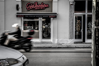 in front of the café barbera in monastiraki in athens a motorcyle pass the street