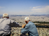 tow old greeks are sitting on the lycabettus and watching the sea of houses in athens