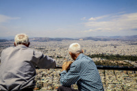 tow old greeks are sitting on the lycabettus and watching the sea of houses in athens