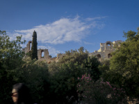 a woman goes past the herodes atticus theatre in athens